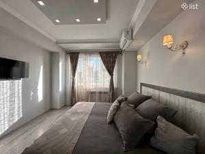 a bedroom with a large bed and a large window at Apartment Zaqyan street in Yerevan