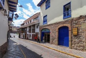 a cobblestone street with a blue door on a building at Muru Suites near Plaza de Armas Cusco by Wynwood House in Cusco