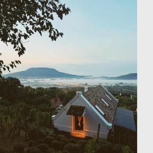 a small white house with a window and a view at Vinonima Vendégház in Hegymagas +14 photos