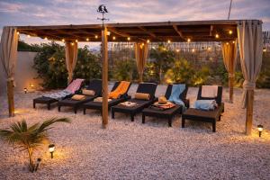 a patio with couches and chairs under a pergola at Apartments Diva Flamingo in Barber