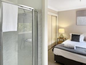 a bedroom with a glass shower and a bed at Glens Haven with Lakeviews and Outdoor Firepit in Wagga Wagga