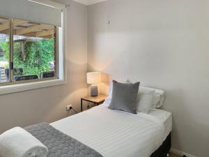 a small bedroom with a bed and a window at Glens Haven with Lakeviews and Outdoor Firepit in Wagga Wagga