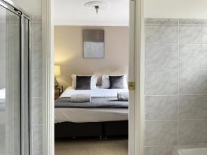 a bedroom with a bed and a walk in shower at Glens Haven with Lakeviews and Outdoor Firepit in Wagga Wagga +23 photos
