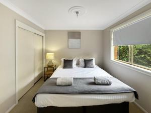 a bedroom with a large bed and a window at Glens Haven with Lakeviews and Outdoor Firepit in Wagga Wagga