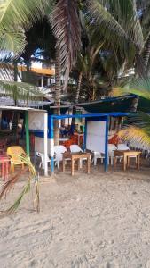 a group of tables and chairs on a beach at Villa del coco Hospedajes in Arboletes