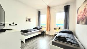 a living room with two beds and a window at TOP Monteurwohnung! Modernes Apartment mit Einzelbetten & WLAN & kostenlosen Parkplätzen & voll ausgestattet in Altena - ALT 01 und 02 in Altena