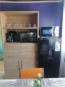 a kitchen with a black refrigerator and a microwave at Apartamento Cuadruple in Isla de Maipo