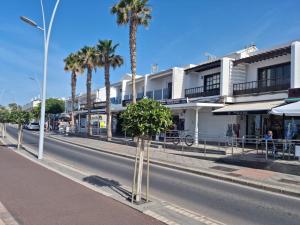 a street with palm trees on the side of a road at Apartamentos Capellania in Puerto del Carmen