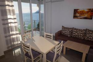 a living room with a table and chairs and a couch at Roxhensi Apartments in Shëngjin