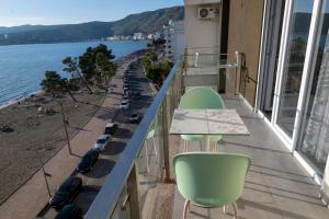 a balcony with green chairs and a view of the beach at Roxhensi Apartments in Shëngjin