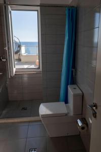 a bathroom with a toilet and a window at Roxhensi Apartments in Shëngjin +291 photos