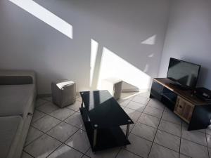a living room with a couch and a tv at MaMontagne in Albertville