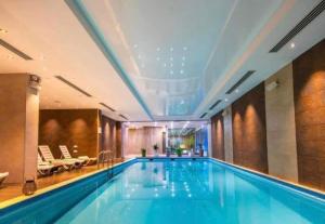 a large swimming pool in a hotel with a ceiling at Frostwood Residence Orbi in Bakuriani