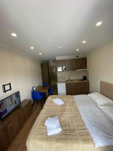 a bedroom with a large bed with two towels on it at Frostwood Residence Orbi in Bakuriani