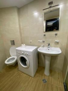 a bathroom with a washing machine and a sink at Frostwood Residence Orbi in Bakuriani +5 photos