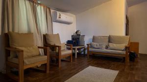 a living room with three chairs and a table at Remal Desert Retreat Bidiyah in Badīyah
