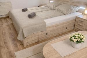 a bedroom with a bed with two pillows and a table at GANCZ APARTMAN in Sárvár