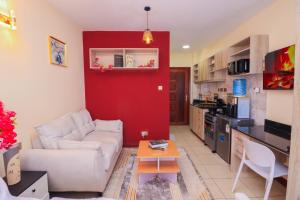 a living room with a white couch and a red wall at charming Naivasha studio apartment in Naivasha