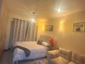 a bedroom with a white bed and a chair at charming Naivasha studio apartment in Naivasha
