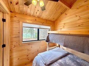 a bedroom with a bed in a wooden cabin at Oceanfront Sunset View Cabin in Milbridge