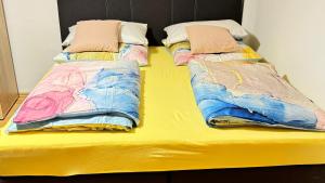 two beds sitting on a yellow bed with pillows at Aaron27 in Meißen