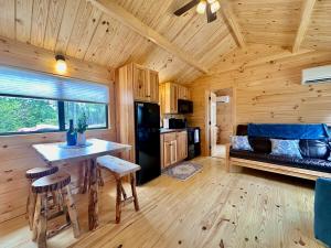 a kitchen and living room of a log cabin at Oceanfront Sunset View Cabin in Milbridge