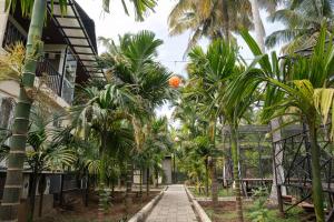 a walkway in front of a house with palm trees at Mountain river farm resort in Agali