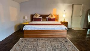 a bedroom with a large bed and two lamps at Remal Desert Retreat Bidiyah in Badīyah