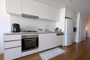 a white kitchen with a stove and a refrigerator at Bedroom with Private Bathroom in cozy shared appartment! in Brisbane