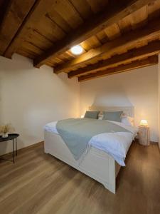 a bedroom with a white bed in a room with wooden ceilings at Apartmán La Šiška - Věžička in Velké Karlovice