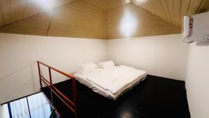 a small bed in a room with a wooden ceiling at Patnem Garden Resort in Patnem
