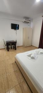a room with a bed and a table and a tv at Hotel kleo Airport tirana in Tirana