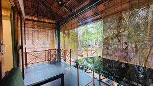a room with a glass table and a large window at Patnem Garden Resort in Patnem