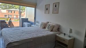 a bedroom with a large bed and a large window at Apartamentos del campus in Manzone