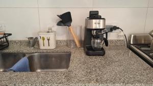 a kitchen counter with a sink and a coffee maker at Apartamentos del campus in Manzone
