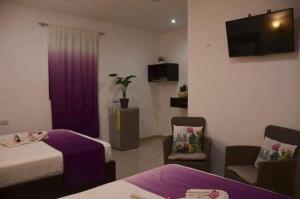 a hotel room with two beds and a purple curtain at La placita hotel in Río Lagartos