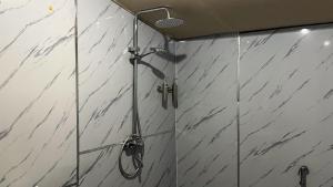 a shower in a bathroom with white marble walls at Remal Desert Retreat Bidiyah in Badīyah +31 photos