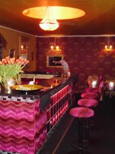 a bar with pink stools in a restaurant at Hostel Kiezbude in Hamburg