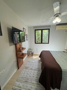 a bedroom with a bed and a flat screen tv at Lysa Paraná in Paraná