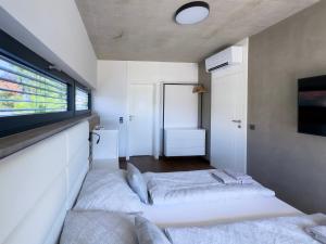 two beds in a small room with a tv at Villa Privlaka Travertino in Privlaka