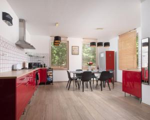 a kitchen with red cabinets and a table with chairs at Zora's apartment in Siófok