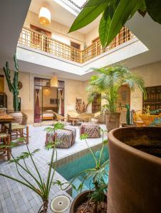 a large living room with a pool and plants at Medina Sun in Marrakesh