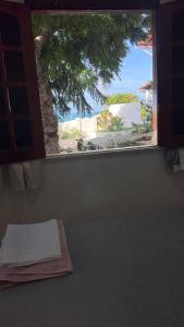 a window in a room with a view of the ocean at CAMA & CAFÉ BED & BREAKFAST HOSPEDARIA MORRO BRANCO 3 MIN A PÉ DAS FALÉSIAs 2 QUADRAS DA PRAIA 1 QUADRA DO MIRANTE & FEIRINHA in Beberibe