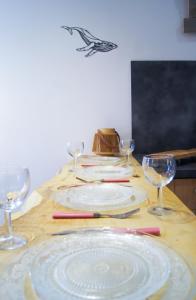 a table with plates and wine glasses on it at Le Havre Familial - 5 couchages climatisé in Romans-sur-Isère +8 photos