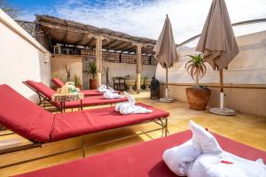 a room with three beds and umbrellas on a patio at Medina Sun in Marrakesh