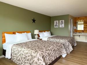 two beds in a bedroom with green walls at The Trail Inn - Grantsburg, WI - 703 WI-70 in Grantsburg