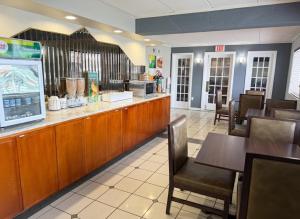 a restaurant with a counter and tables and chairs at Quality Inn Milan-Sandusky in Milan