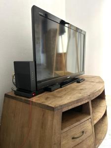 a flat screen tv sitting on a wooden stand at La Cachette Urbaine in Albi