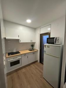 a kitchen with white cabinets and a refrigerator at Diplomatic Salou in Salou
