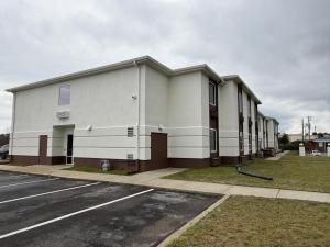 a large white building with a parking lot at Regency Inn & Suites in Milton
